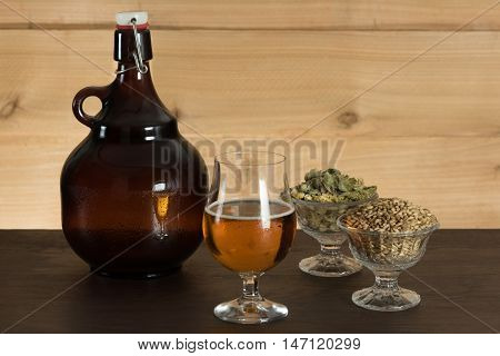 Goblet of beer, growler, hops and malts