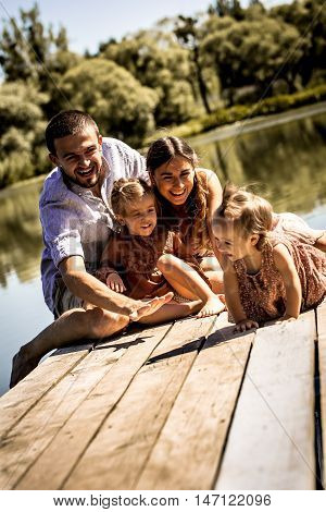 Young Family On Pier Near Lake
