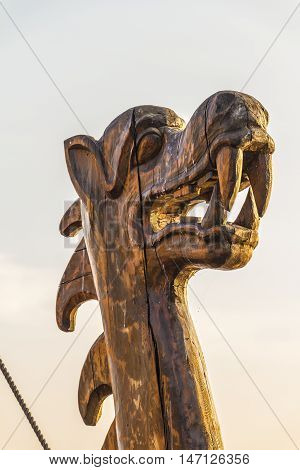 The wooden figure of a dragon's head on the prow of an ancient ship.