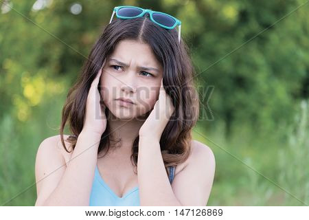 Portrait of a teen girl thinking about a problem on the nature