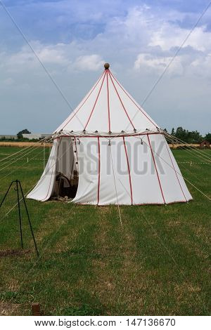 White Tent And Wooden Tripod For Bonfire On Meadow