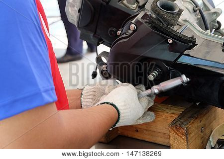 Hands of disassembly kit motorcycle in repair service. Automotive engine disassembly kit motorcycle.