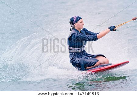 Young woman kneeboarding, toned image, horizontal image