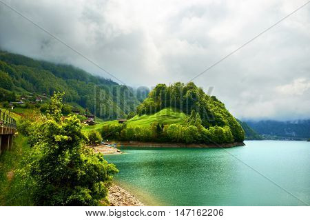 Beautiful emerald mountain lake Lungern in Switzerland under low clouds