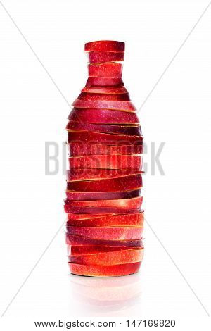Bottle made from red sliced apples on white