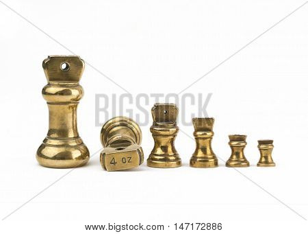 A set of antiques brass imperial weights isolated on a white background. showing 4oz