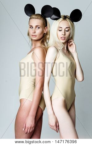 Blonde girls wearing bodysuits and black mouse ears