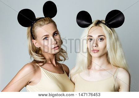 Blonde girls wearing bodysuits and black mouse ears