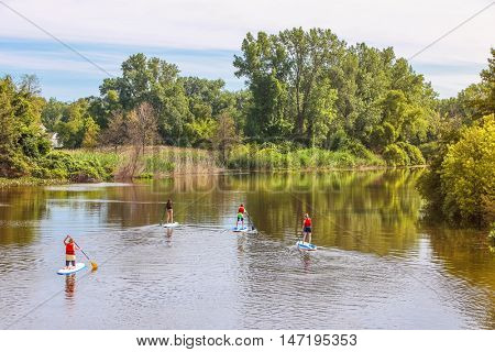 Group of people Paddleboarding on a river at sunrise