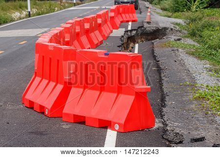 row of red plastic barrier Preventing accidents form road collape.