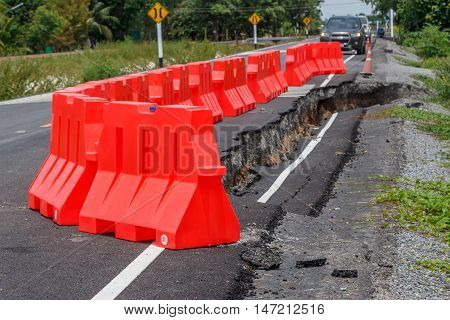 row of red plastic barrier Preventing accidents form road collape.
