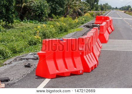 row of red plastic barrier Preventing accidents form road collape.