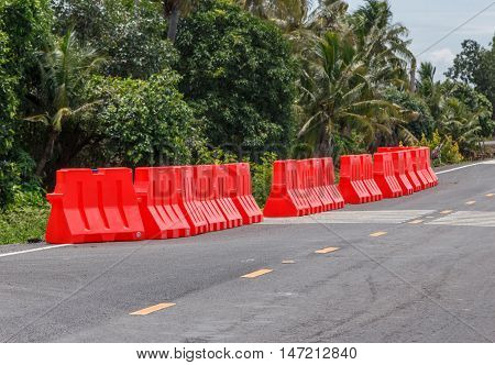 row of red plastic barrier Preventing accidents form road collape.
