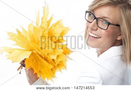 portrait of attractive  caucasian smiling woman isolated on white studio shot looking at camera hand holding yellow marple autumn leaves