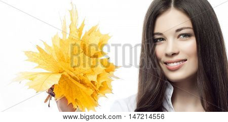 portrait of attractive  caucasian smiling woman brunette isolated on white studio shot hand holding yellow marple autumn leaves