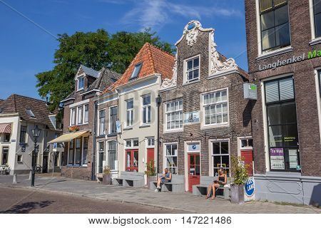 ZWOLLE, NETHERLANDS - AUGUST 31, 2016: People sitting in the sun in front of a historical building in Zwolle