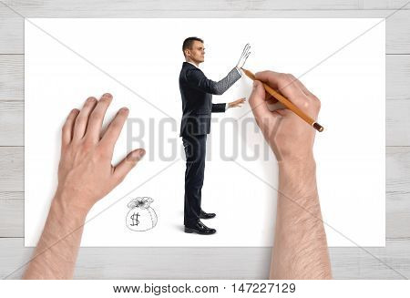 Close up view of man's hands drawing a businessman and a scak of money on sheet of paper with pencil. Earning money. Success and profit. Employment issues.