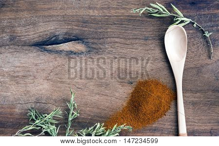 Ground pepper and mountain herbs on wooden background