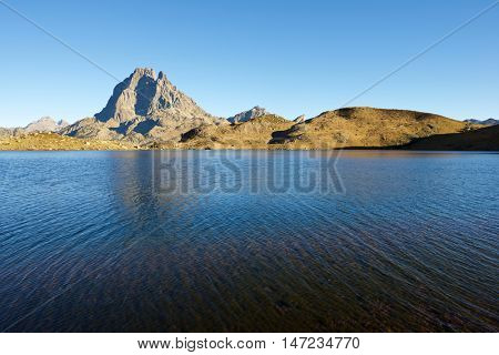 Midi Dossau Peak reflected in Gentau lake. Ossau Valley, Pyrenees National Park, Pyrenees, France.