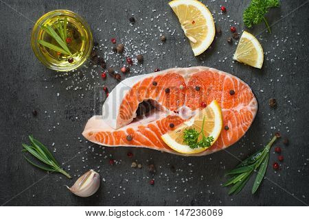 Fresh fish. Salmon. Raw salmon steak with sea salt pepper and herbs. Food background.