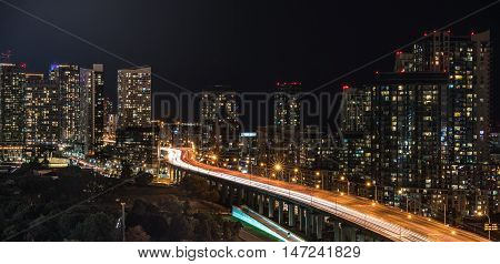 Glowing light streaks from Gardiner Expressway as traffic  never stops.  Hot & muggy summer night in Lakeside 
Toronto, Canada.