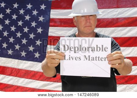 A man poses in front of am American flag with a Deplorable Lives Matter sign.
With his dog.