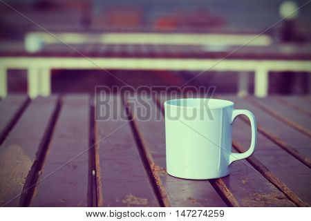 Coffee cup on wooden table (vintage background)