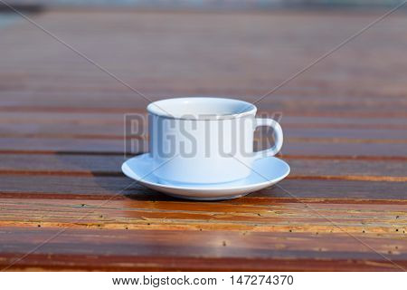 Coffee cup on wooden table (vintage background)