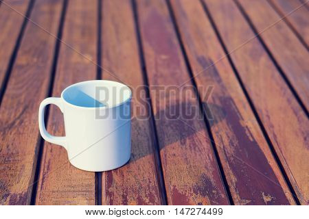 Coffee cup on wooden table (vintage background)