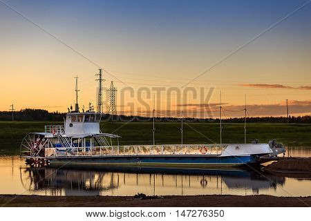 a ferry to transport people across the river at sunset