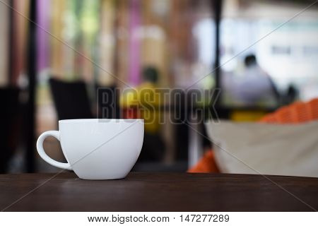 Coffee cup on table in cafe (vintage background)