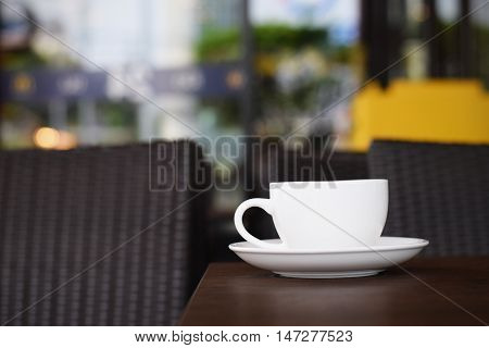 Coffee cup on table in cafe (vintage background)