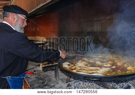 VALENCIA, SPAIN - MARCH 21, 2015: Local chef preparing a traditional Valencian paella with meat and chicken in Valencia Spain