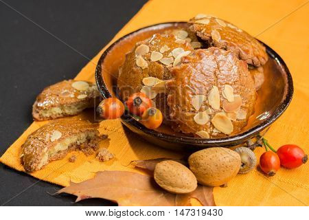 Typical Dutch filled spicy cookies with almonds on autumn colored and dark background