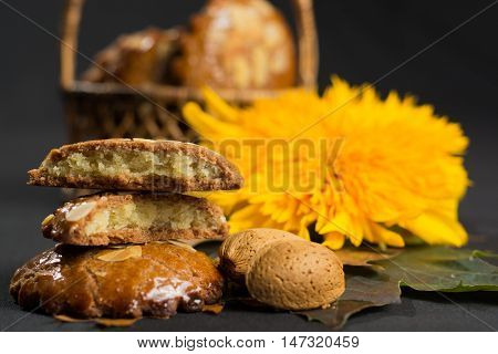 Typical Dutch filled spicy cookies with almonds on autumn colored and dark background