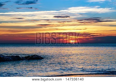 Tropical colorful dramatic sunset with cloudy sky . Evening calm on the Gulf of Thailand. Bright afterglow.