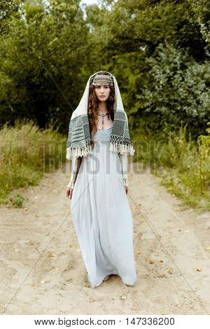 Young girl in traditional folk Crimean Tatar clothes walking in fields