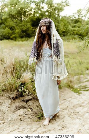 Young girl in traditional folk Crimean Tatar clothes walking in fields