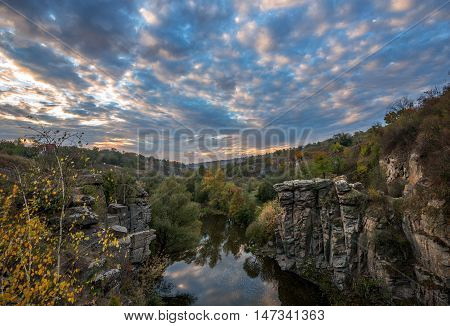 Buky Canyon (River Hirs'kyi Tikych - Ukraine) in autumn season. Sky with clouds is multicolored.