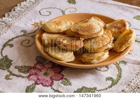 Olady - traditional ukrainian pancakes on tablecloth with flowers.