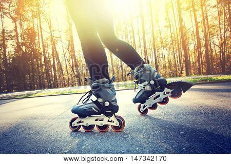 Teenage girl on roller skates at summer. Inline skates sport conceptual image.