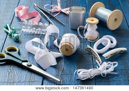 Making beautiful bows for decoration hair and gifts in the art kanzashi. Step by step photo instructions. Step 1. Preparation of materials (tape rubber barrettes) and tools (scissors tweezers)