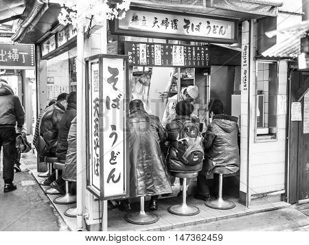 Tokyo, Japan - February 19 2014: A group of men eating in a small izakaya (bar) in a little alley of Shinjuku district Tokyo.