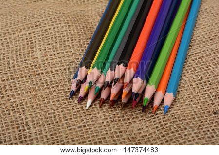 Set of Colorful pencils isolated on jute background.