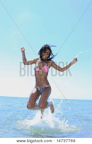 krásná černoška portrét v bikiny na pláži skákání