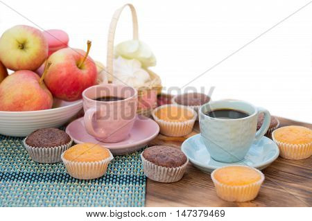 Still life of served coffee cups macaroon cookies marshmallows and apples