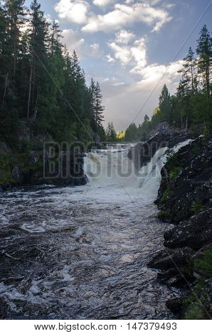 Kivach waterfall at sunset and the forest on the bank. Karelia.