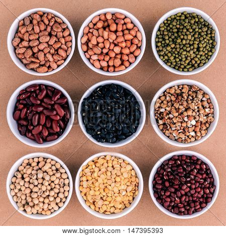 Mixed Beans And Lentils In The White Bowl  On Brown Background. Mung Bean, Groundnut, Soybean, Red K