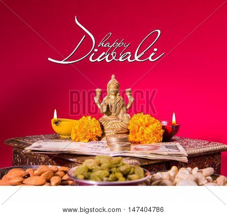 Happy Diwali Greeting card showing oil lamp or diya with crackers, sweet or mithai, dry fruits, indian currency notes, marigold flower and statue of Goddess Laxmi or Lakshmi on diwali night