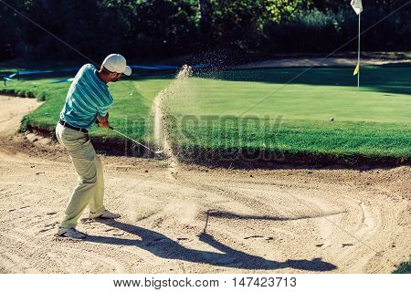 Golfer in sand trap, toned image, green, horizontal image